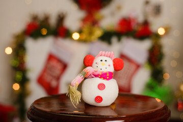 Snowman made of wool and yarn with Christmas background. Decorative crafts for Christmas.