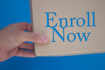 Enroll Now word with cardboard box. Brown folded card box.