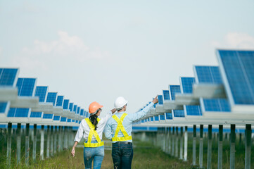 Asian Young Inspector Engineer man and female walking checking operation in solar farm