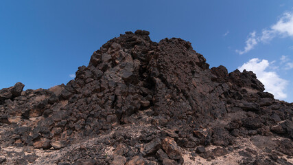 Dark volcanic matter shaped into sharp hills around Lobos Island, Spain