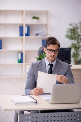 Young male employee and too much work in the office
