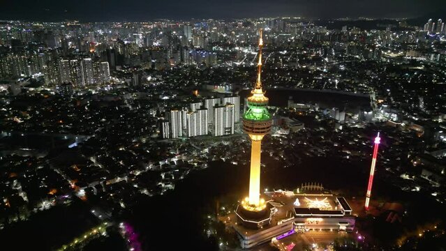 Iconic Korean Daegu tower 83 illuminated landmark aerial view reversing across nighttime cityscape