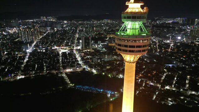 Aerial view passing iconic Daegu tower 83 illuminated Korean observation landmark and nighttime skyline