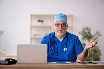 Old male doctor working in the clinic