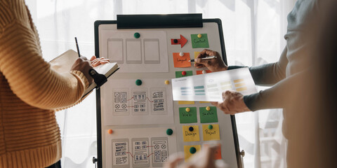 Close up ux developer and ui designer brainstorming about mobile app interface wireframe design on...
