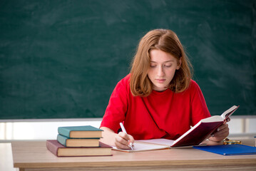 Young female student preparing for exams in the classroom