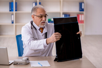 Old male doctor radiologist working in the clinic