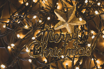 San Nicolás o papa Noel, en fondo de luces de navidad desenfocadas y letras doradas de Merry christmas, en fondo dorado, concepto de detalles y decoración navideña. 