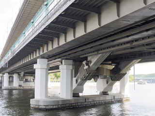 Subway railway bridge across the river with concrete piers
