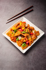 Chilli chicken which is a popular Indo-Chinese starter dish, served on a plate or bowl. Selective focus