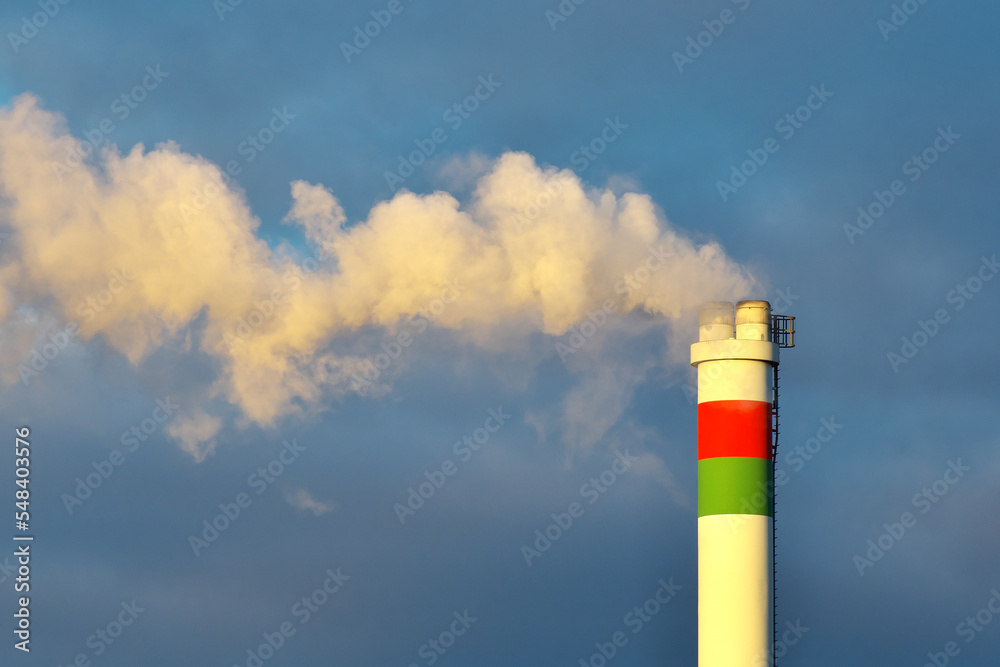 Wall mural smoke coming out of a large factory chimney. close-up of smoke coming out of chimneys against the sk