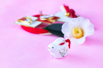 年賀状　卯年の兎と白い椿の花と紅白の水引リース（ピンクバック）