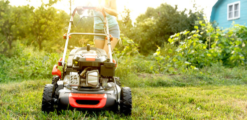 a lawn mower mows the lawn on a sunny summer evening
