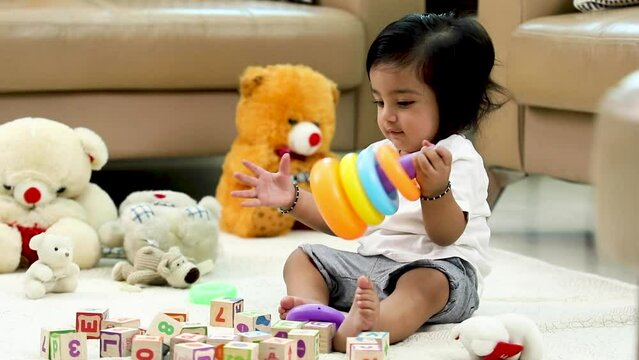 Stock video of a baby boy playing with his toys at home.