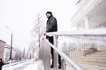 A man in black warm clothes and a white shirt. winter. urban landscape. snow covered streets