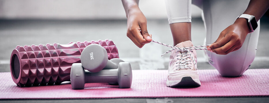 Fitness, weights and woman tying shoes before workout in gym for health, wellness and strength. Sports, training and closeup of athlete with laces to tie while preparing to exercise in a sport center