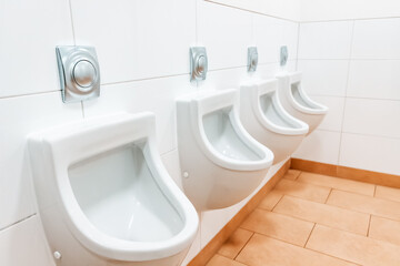 Urinals in a public men's toilet. The concept of sanitary cleaning and urology