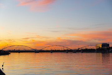 Fototapeta na wymiar Pedestrian bridge over a lake at sunset.