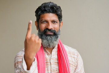 Young Indian farmer showing finger after voting. voting sign in india