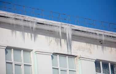 Obraz premium Icicles hang from the roof of the house.