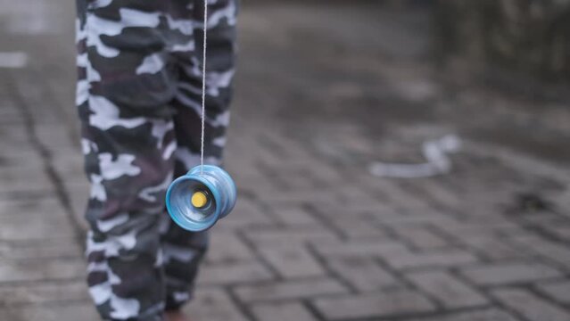 Cinematic shot of spinning yoyo that played by a child with bokeh
