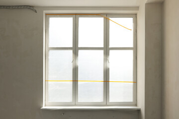 Window and sill covered by plastic film indoors