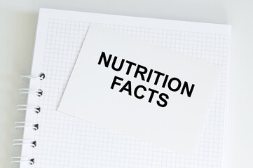 NUTRITION FACTS text on a notebook on a table, a medical concept.