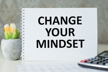 Change Your Mindset text notepad and on office wooden table