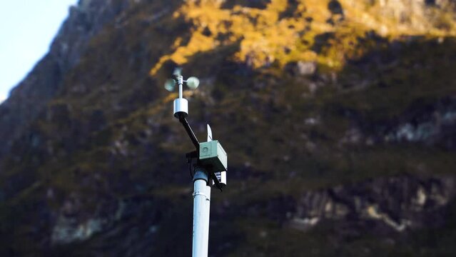 Automatic weather station with weather monitoring system, against majestic mountain range of New Zealand