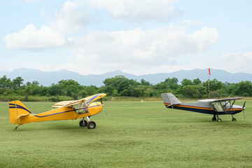 View of beautiful ultralight airplanes in field on autumn day