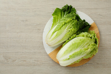 Fresh ripe Chinese cabbages on white wooden table, top view. Space for text