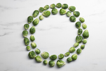 Frame of Brussels sprouts on white marble table, flat lay. Space for text