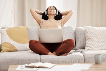 Black woman, headphones and laptop to relax, on couch for wellness and meditation in living room....