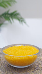 Bowl with bath salt on wicker mat in bathroom