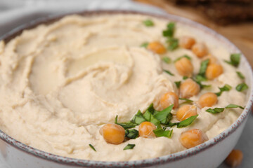 Bowl of delicious hummus with chickpeas, closeup