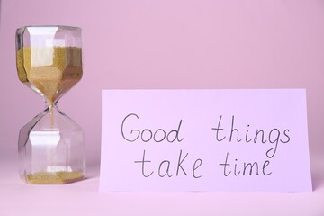 Card with phrase Good Things Take Time and sand clock on pink background. Motivational quote