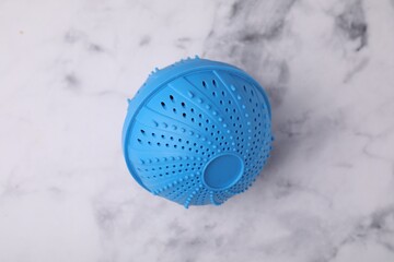 Dryer ball for washing machine on white marble table, top view
