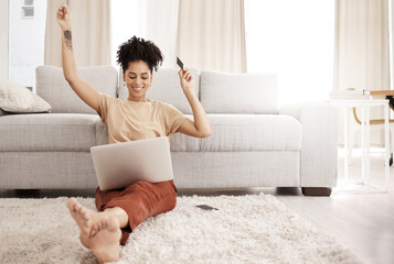 Black woman, laptop and happy with credit card, ecommerce and approved loan in lounge. Young...
