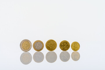 complete set of euro coins standing on a white table with reflections