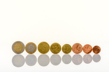 complete set of euro coins standing on a white table with reflections