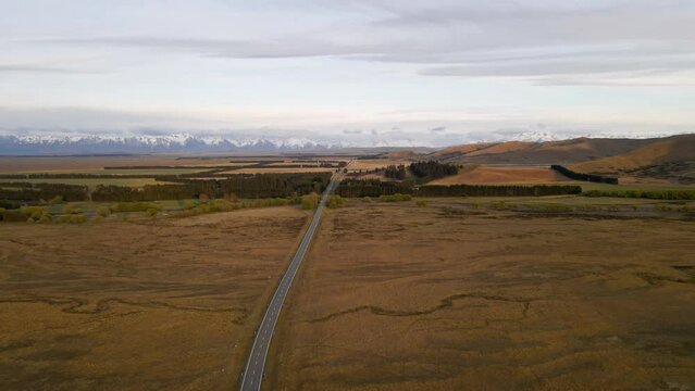 Countryside Highway In The Mackenzie District Leading Towards A Majestic Mountain Range. Aerial Tracking Shot