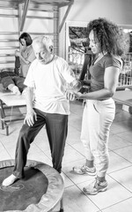 Nurse assisting elder people in a rehab facility gym