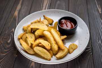 French fries with ketchup on plate on wooden background. junk food