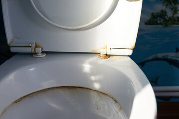 Old and dirty toilet seats, yellow stains, poor condition.