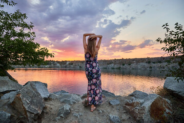 Girl at sunset on the background of the lake
