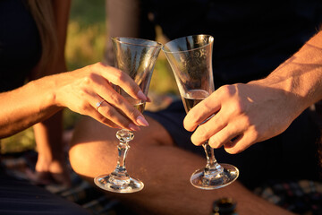 Couple in love drinking champagne from glasses at sunset