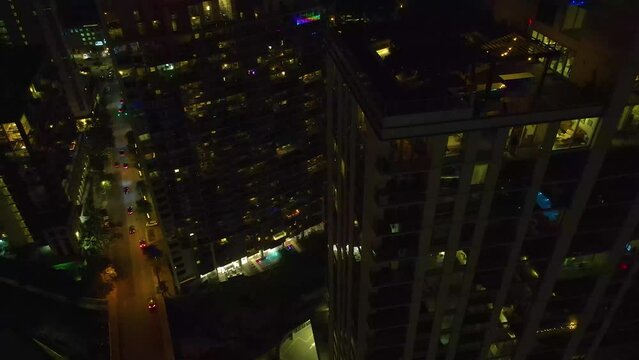 Austin Texas skyline at night. Drone footage flies above apartment buildings while the drone records footage of the ground and the building. Video has a cinematic feel that's good for a short film.