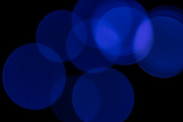 Blue blurry bokeh lights on black background