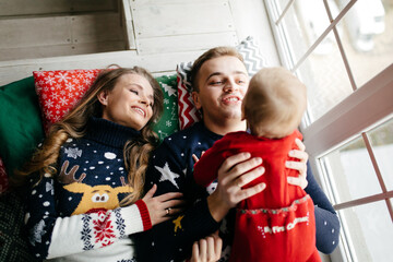 Happy smiling family at  studio on background of the Christmas tree with gift