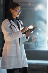 Doctor, tablet and woman planning at night in medical office, hospital and clinic for research,...